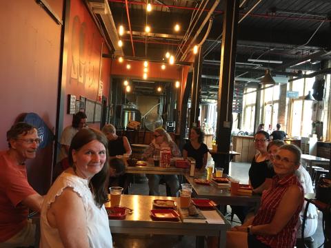 People sitting around a table at the brewery book discussion.