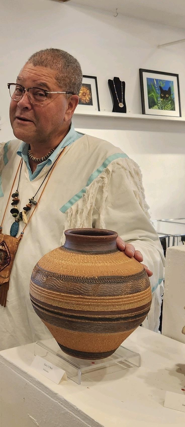 man stands with pottery vase